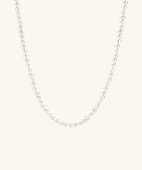 Close-up of the Paradigm Pearl Necklace, showcasing handcrafted freshwater pearls on a delicate chain with a sterling silver clasp.