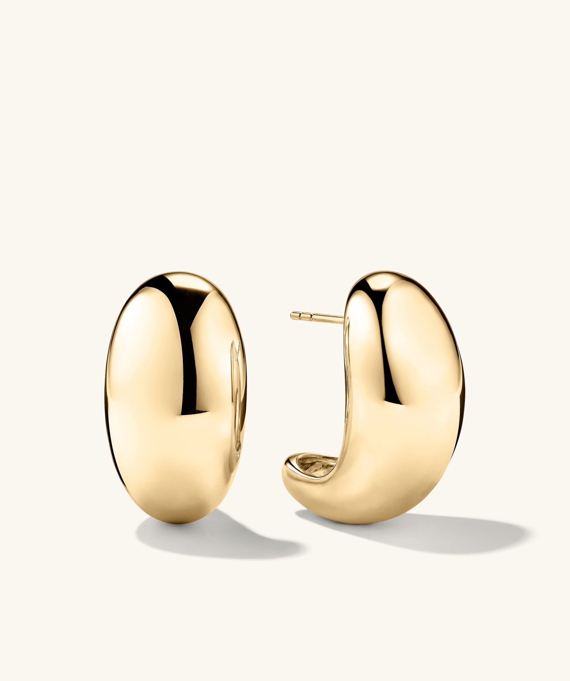 Mega DÃ´me Earrings: A pair of large, gold, puffed earrings, designed to capture attention with their bold, standout style.