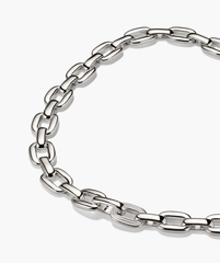 Stevie Chain: Polished silver link necklace with elongated, rounded-rectangle links, featuring a unique textured link for added intrigue, arranged in a loose circle.