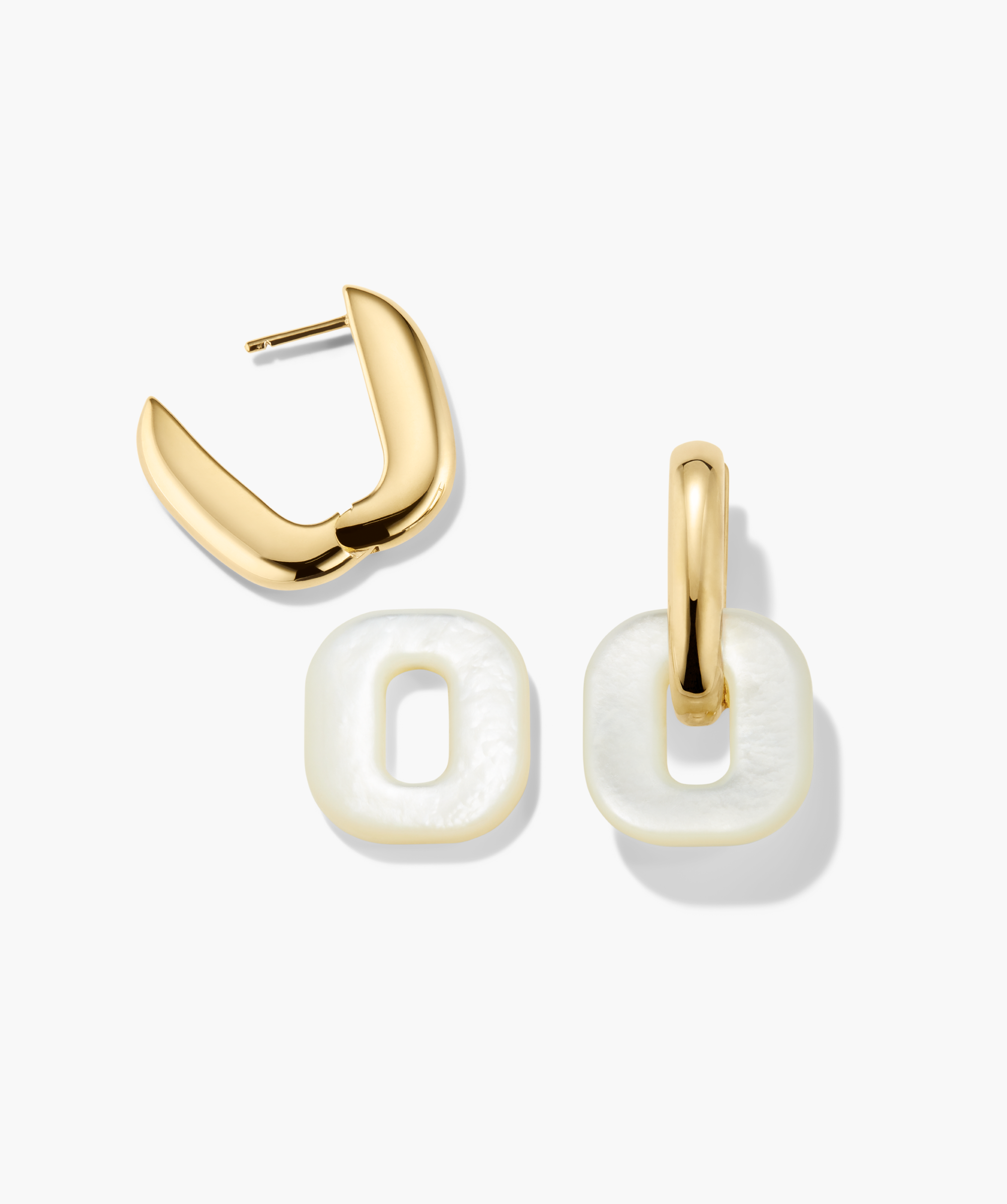 Stevie Hoops earrings feature gold-tone huggie hoops with detachable square pearl-like charms, offering versatile styling with interchangeable, reversible designs.