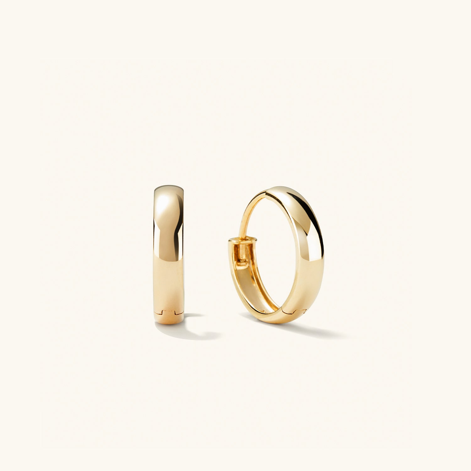 Bold Small Hoops: Close-up of a pair of gold hoop earrings, showcasing their smooth, elegant design. Perfect for elevating any outfit.