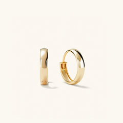 Bold Small Hoops: Close-up of a pair of gold hoop earrings, showcasing their smooth, elegant design. Perfect for elevating any outfit.