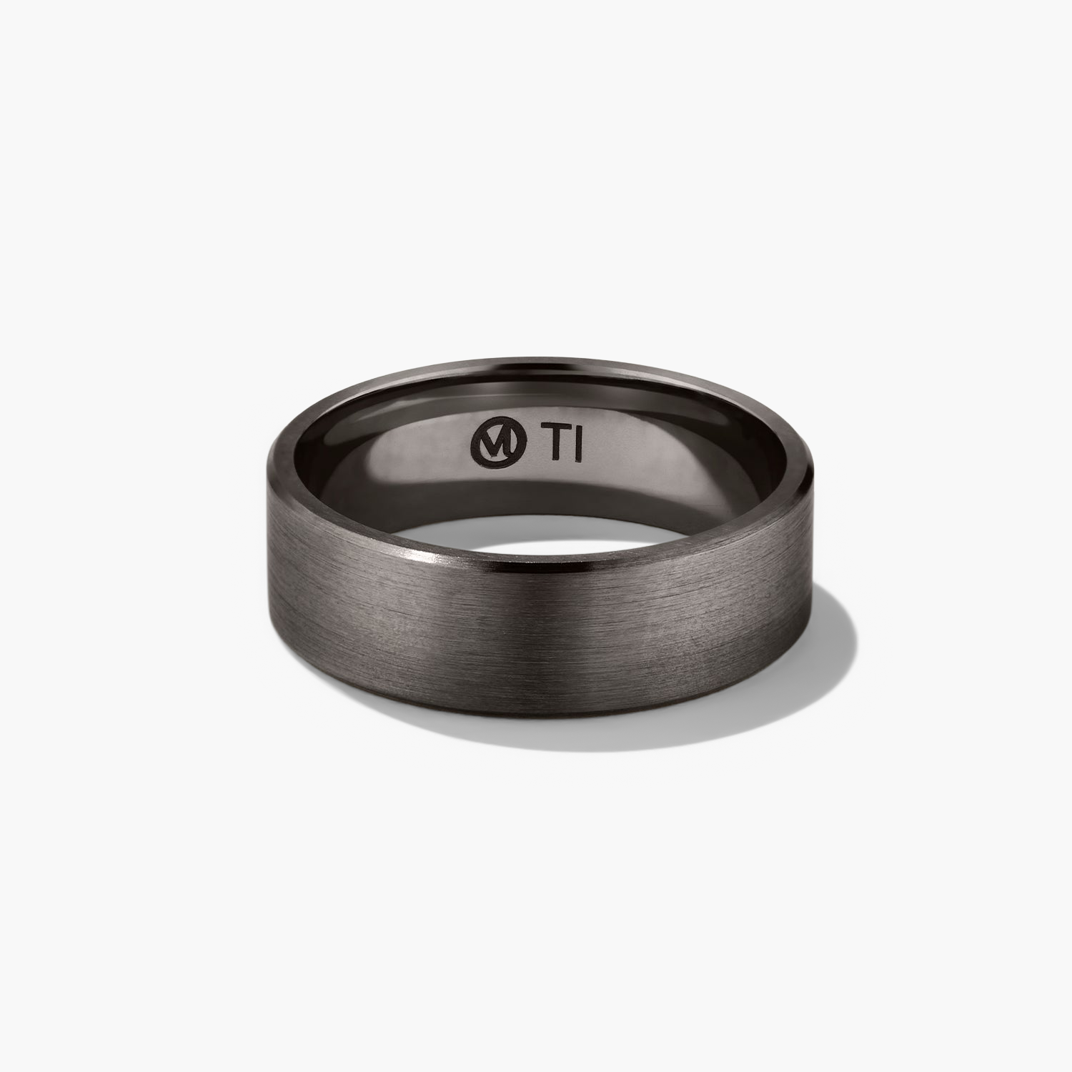 6mm Smooth Band: close-up of a black ring with the letter 'M' engraved, showcasing its lightweight and lasting design, perfect for your next chapter.