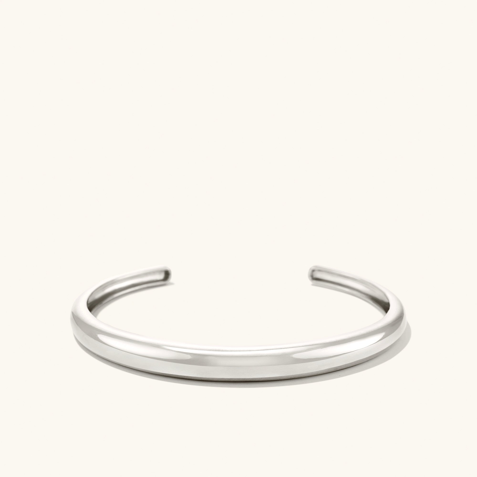 DÃ´me Cuff Bracelet: A sleek, silver bracelet with a minimalist design, inspired by dome architecture, placed against a plain white background.