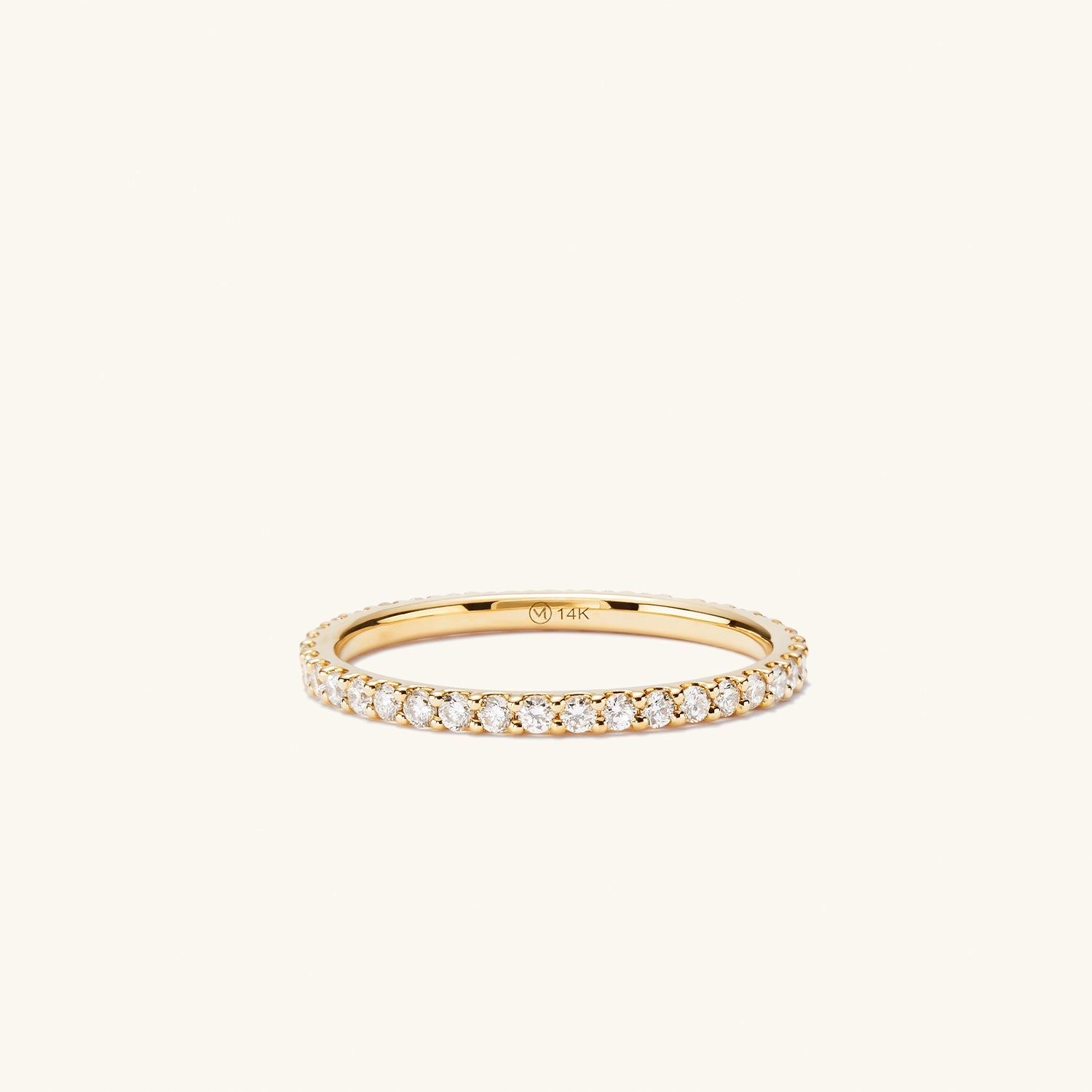 Diamond Eternity Band: Close-up of a slim gold ring adorned with multiple hand-set diamonds in open prongs, showcasing a sparkling, elegant design.
