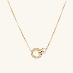 PavÃ© Diamond Linked Necklace: a 14k gold chain featuring two interlinked rings, one adorned with Kimberley Process compliant diamonds, symbolizing personal bonds.
