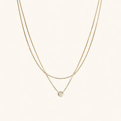 Layered Opal Necklace featuring a gold chain with a small, natural opal pendant.