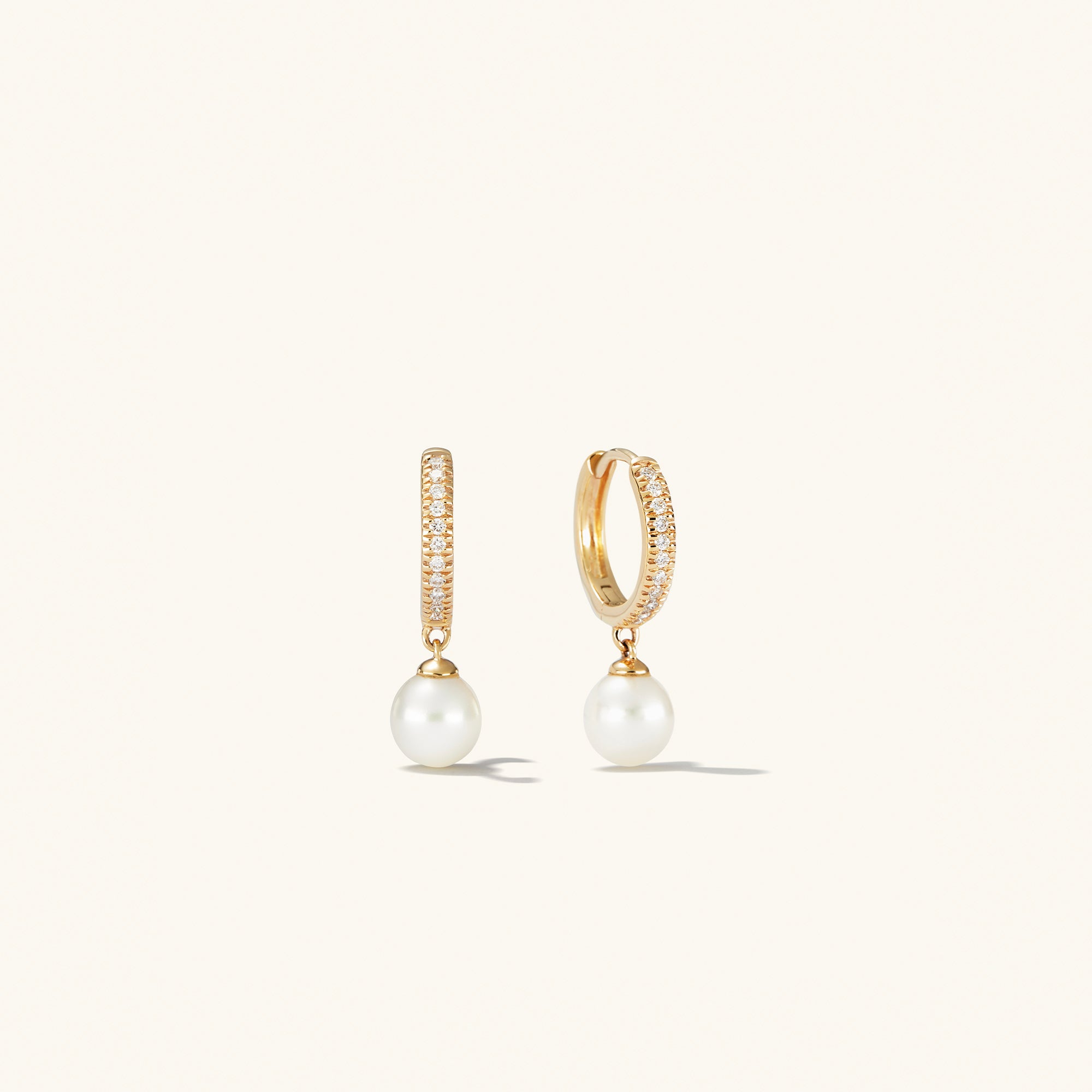 PavÃ© Diamond Pearl Huggies: 14k gold earrings with 22 pavÃ©-set diamonds and a round freshwater pearl, elegantly designed for versatile wear.