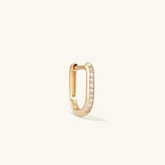 Single PavÃ© Diamond Huggie U Hoop: A close-up of a handcrafted 14k gold earring with diamonds, adding dimension to your ear stack.