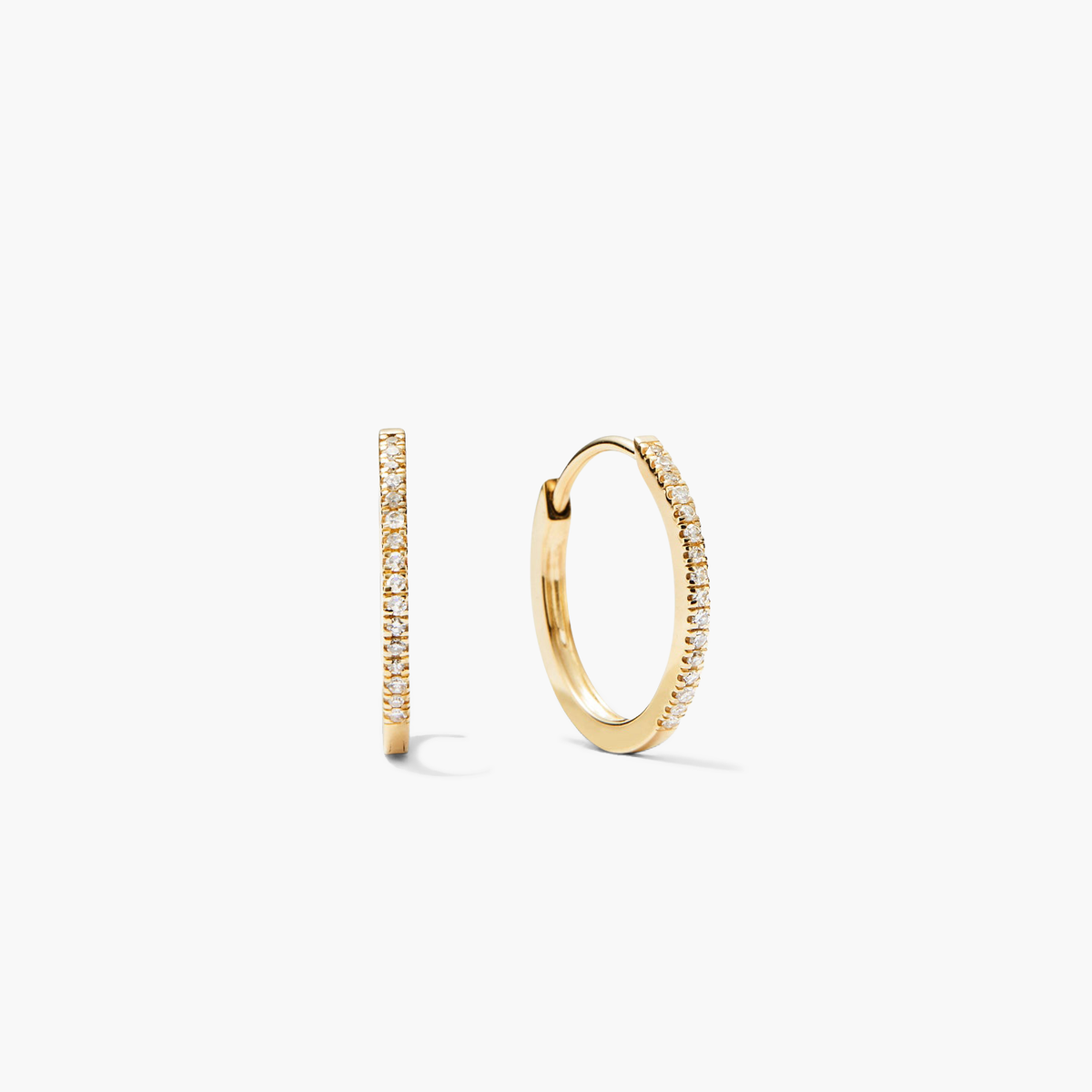 PavÃ© Diamond Small Hoops: Slim yellow-gold hoops with front-facing white stones, shown in profile and angled, handcrafted in recycled 14k gold for versatile, elegant styling.