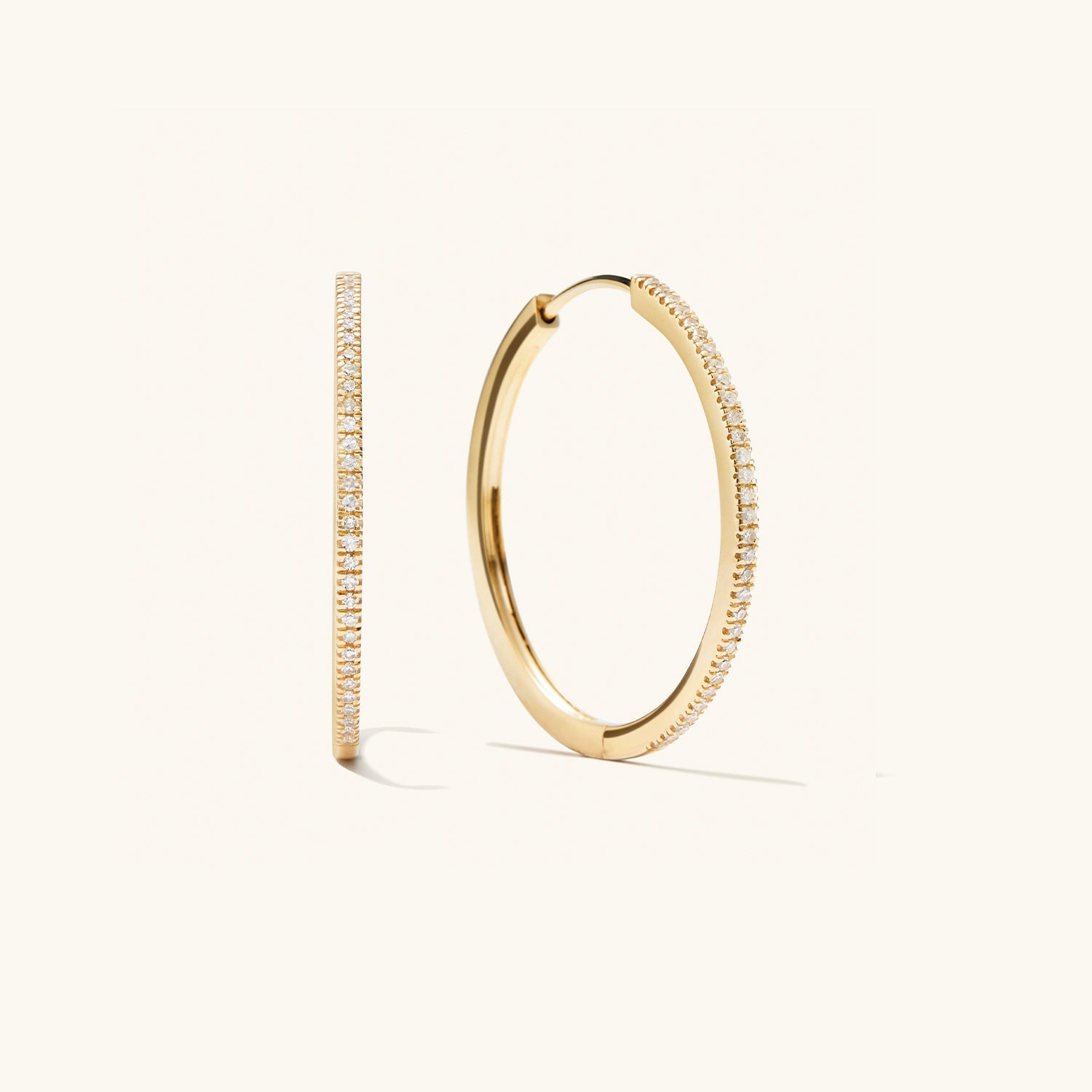 PavÃ© Diamond Large Hoops: A pair of handcrafted 14k solid gold hoop earrings with pavÃ© diamonds, designed for versatile wear.