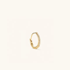 Single PavÃ© Diamond Huggie Hoop: a handcrafted 14k solid gold earring featuring a row of pavÃ© diamonds, designed for versatile wear and elevating any outfit.
