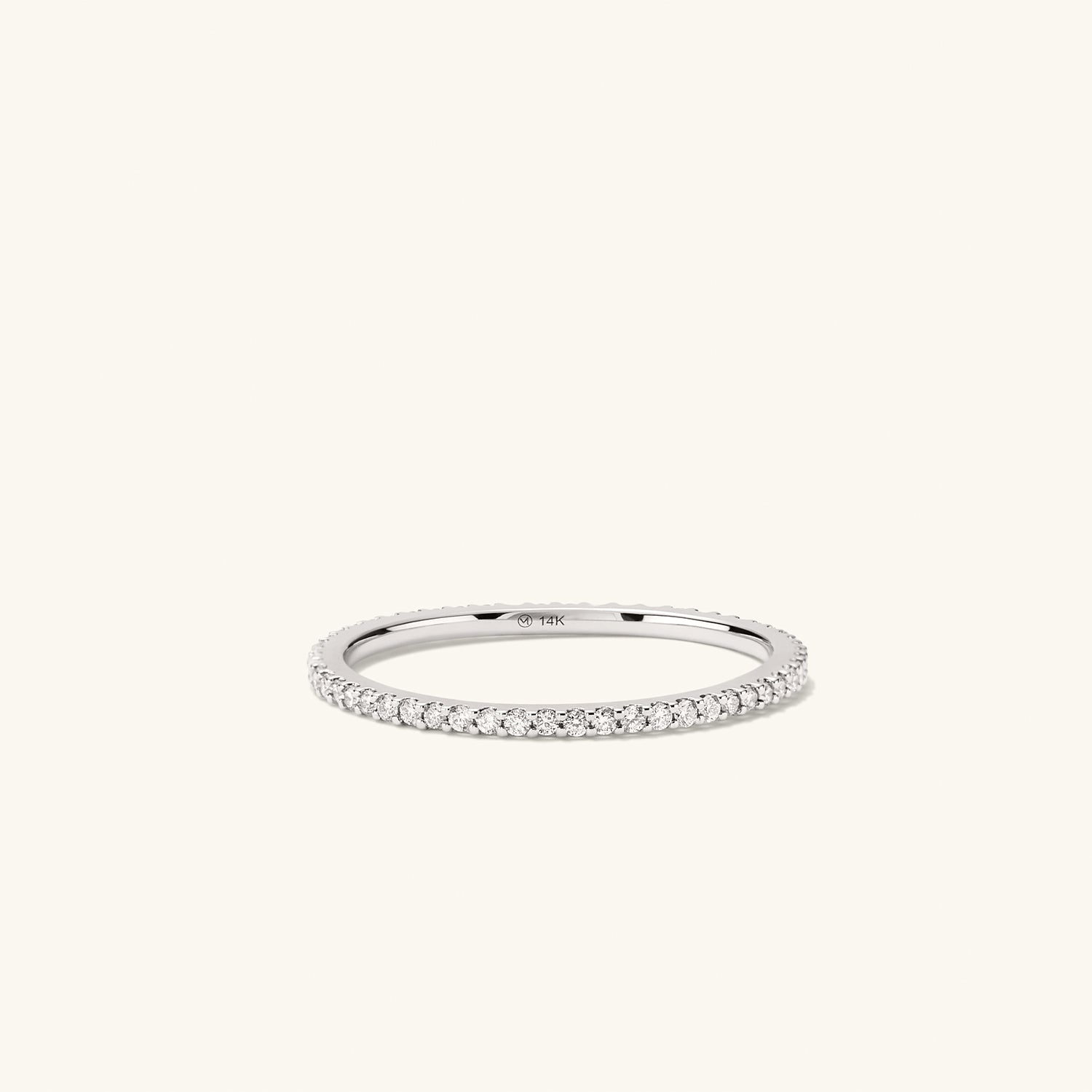 Slim Diamond Eternity Band: A silver ring adorned with numerous hand-set diamonds, featuring open prongs to enhance their sparkle.