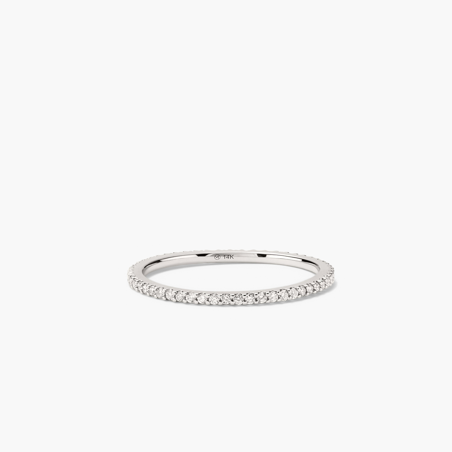 Slim Diamond Eternity Band: A silver ring adorned with numerous hand-set diamonds, featuring open prongs to enhance their sparkle.