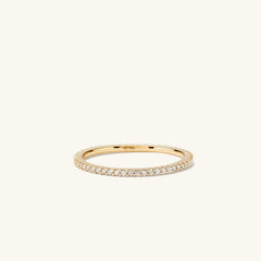 Slim Diamond Eternity Band: a close-up of a slim gold ring featuring a continuous circle of hand-set diamonds in open prongs, showcasing its elegant sparkle.
