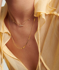 Person wearing a Serpentine Chain Necklace, shown in close-up, highlighting its minimal yet bold design. A versatile fashion accessory suitable for various occasions.