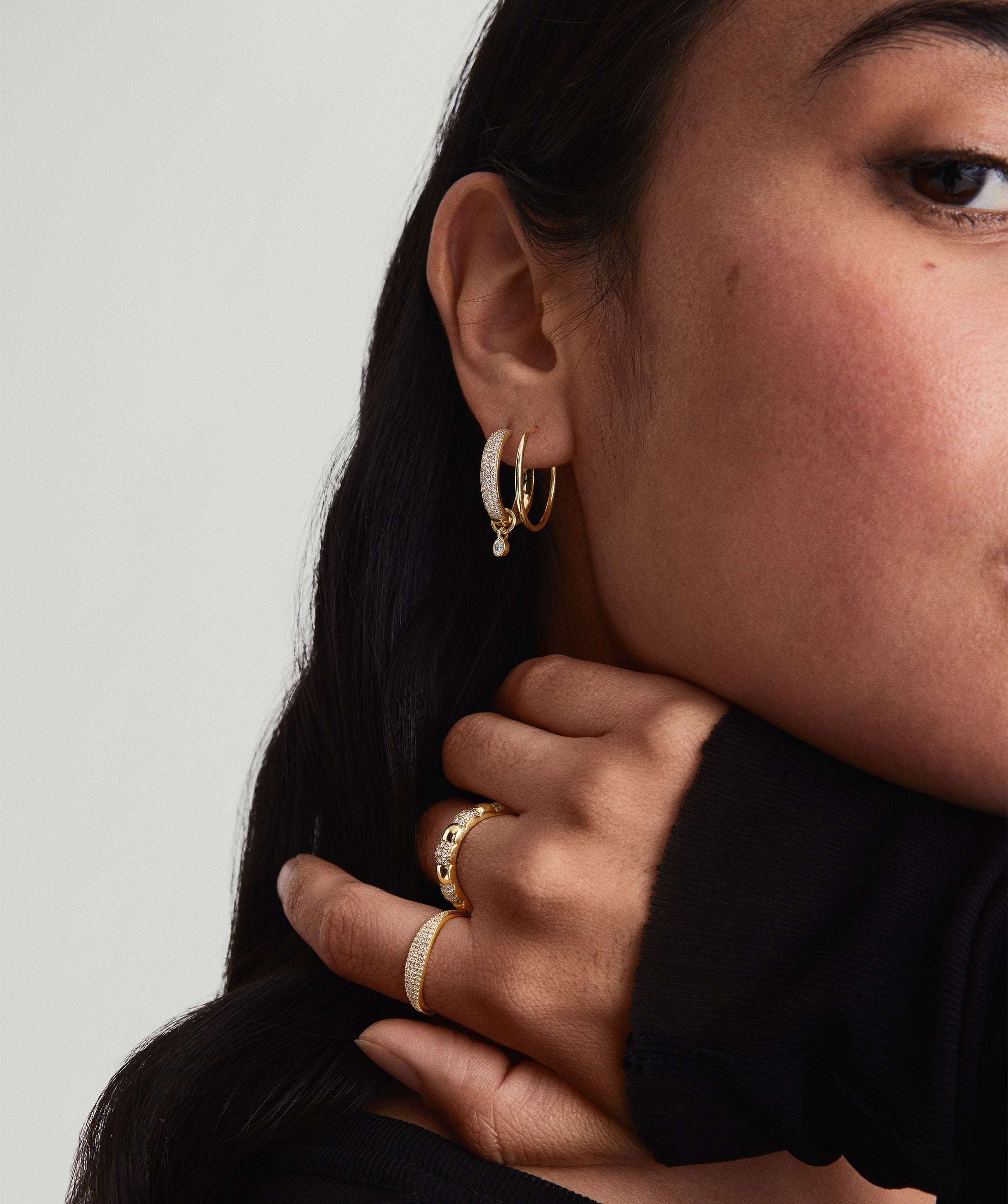 Close-up of a woman's ear wearing the lightweight, handcrafted 14k solid gold Between Hoops.