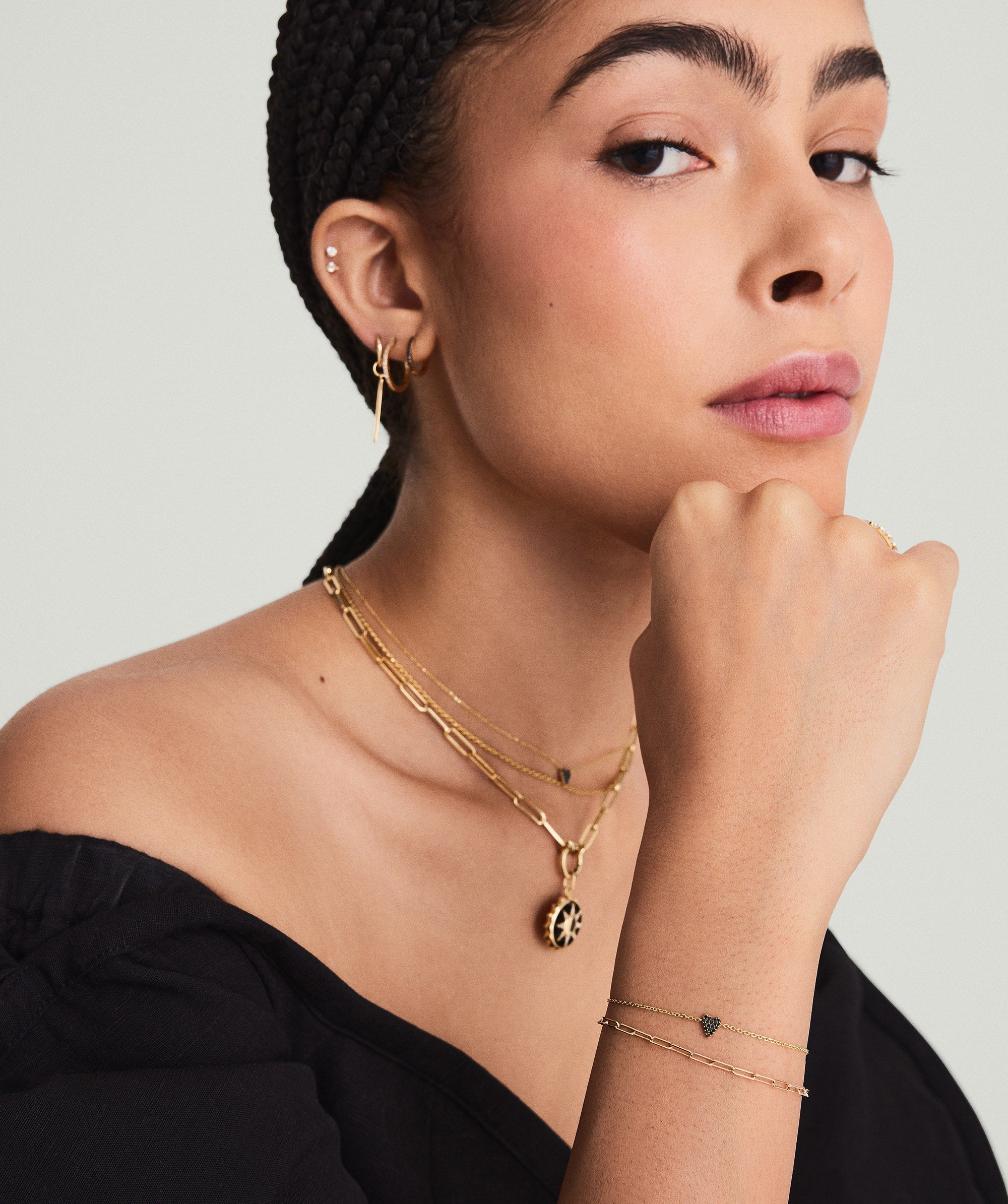 Woman with hand on chin, showcasing a Mini Heart PavÃ© Diamond Bracelet, highlighting its delicate design and playful mini heart accents.