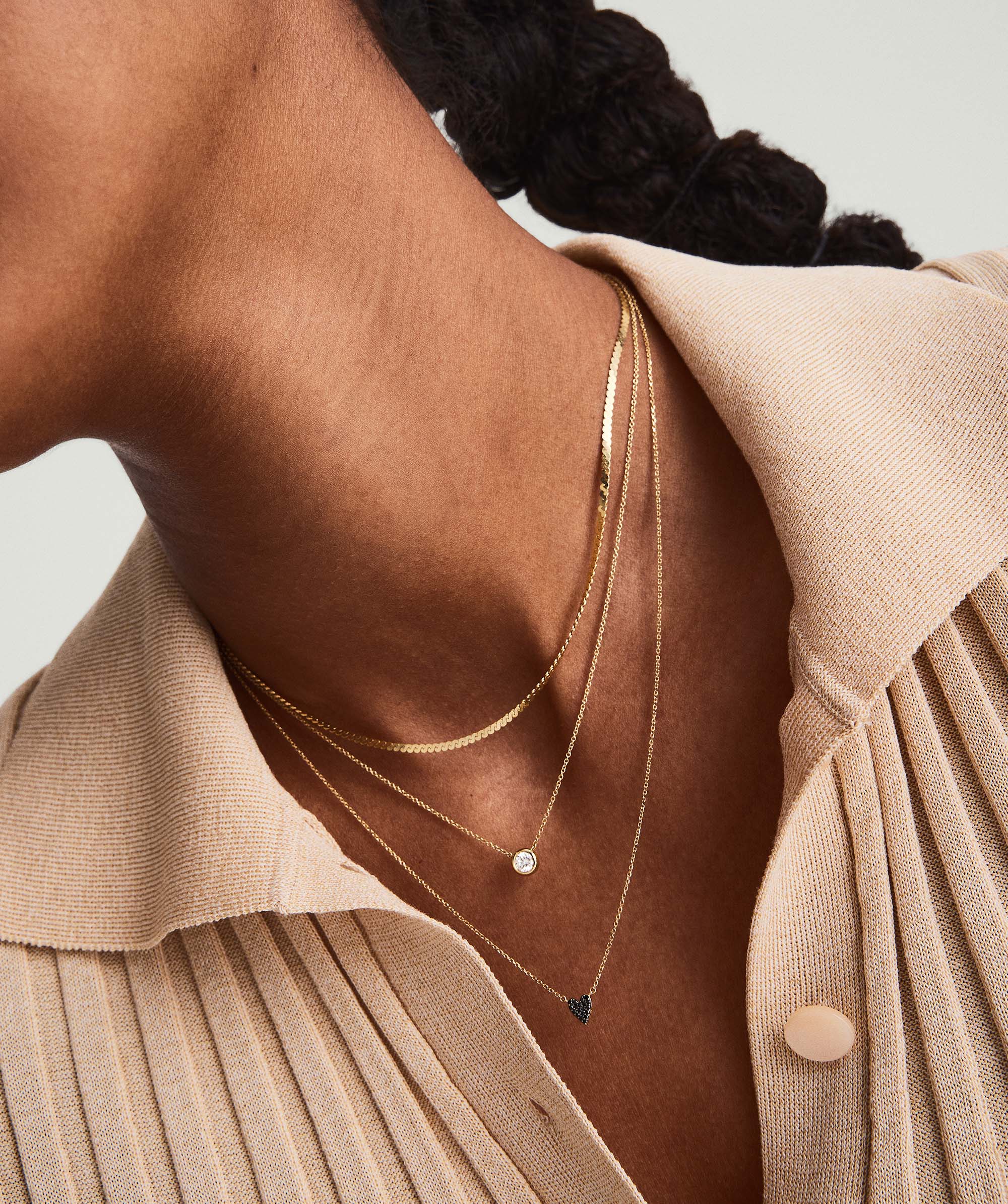 Person wearing the Mini Heart PavÃ© Diamond Necklace, showcasing the elegant design and sparkling diamonds on a delicate chain.