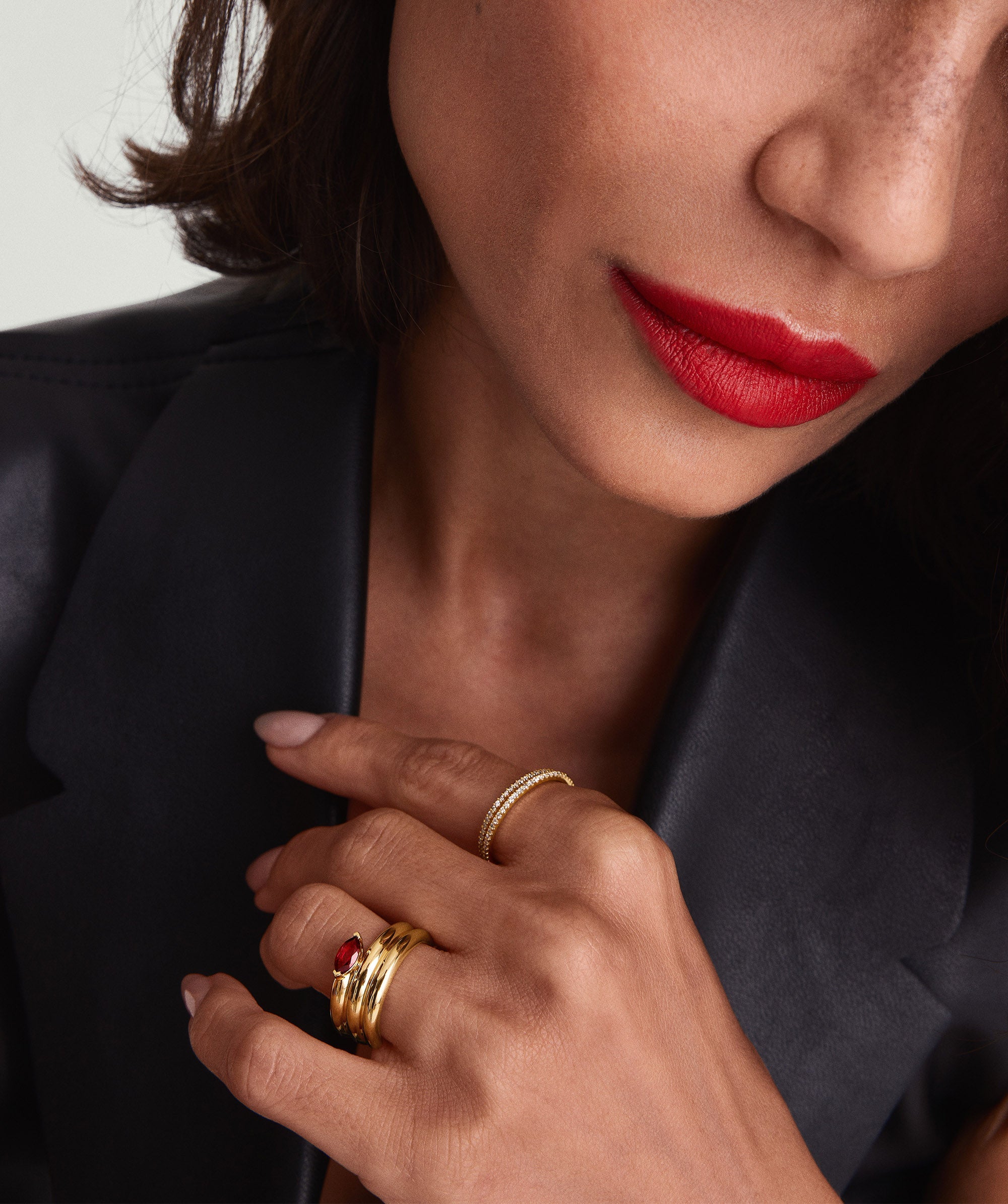 Boa Gemstone Coil Ring showcased on a woman's hand, featuring a red stone and 18k gold vermeil, emphasizing its statement-making design and intricate craftsmanship.