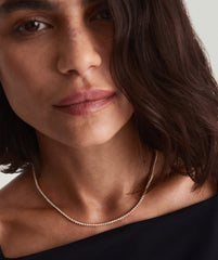 Diamond Tennis Necklace 1.8mm: Close-up of a woman wearing a 14k solid gold necklace with sparkling diamonds, highlighting the intricate clasp and safety arms.
