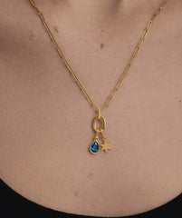 Small Pear Pendant on a gold chain, featuring a blue gem, elegantly worn as a necklace, enhancing everyday style with its unique charm and shine.