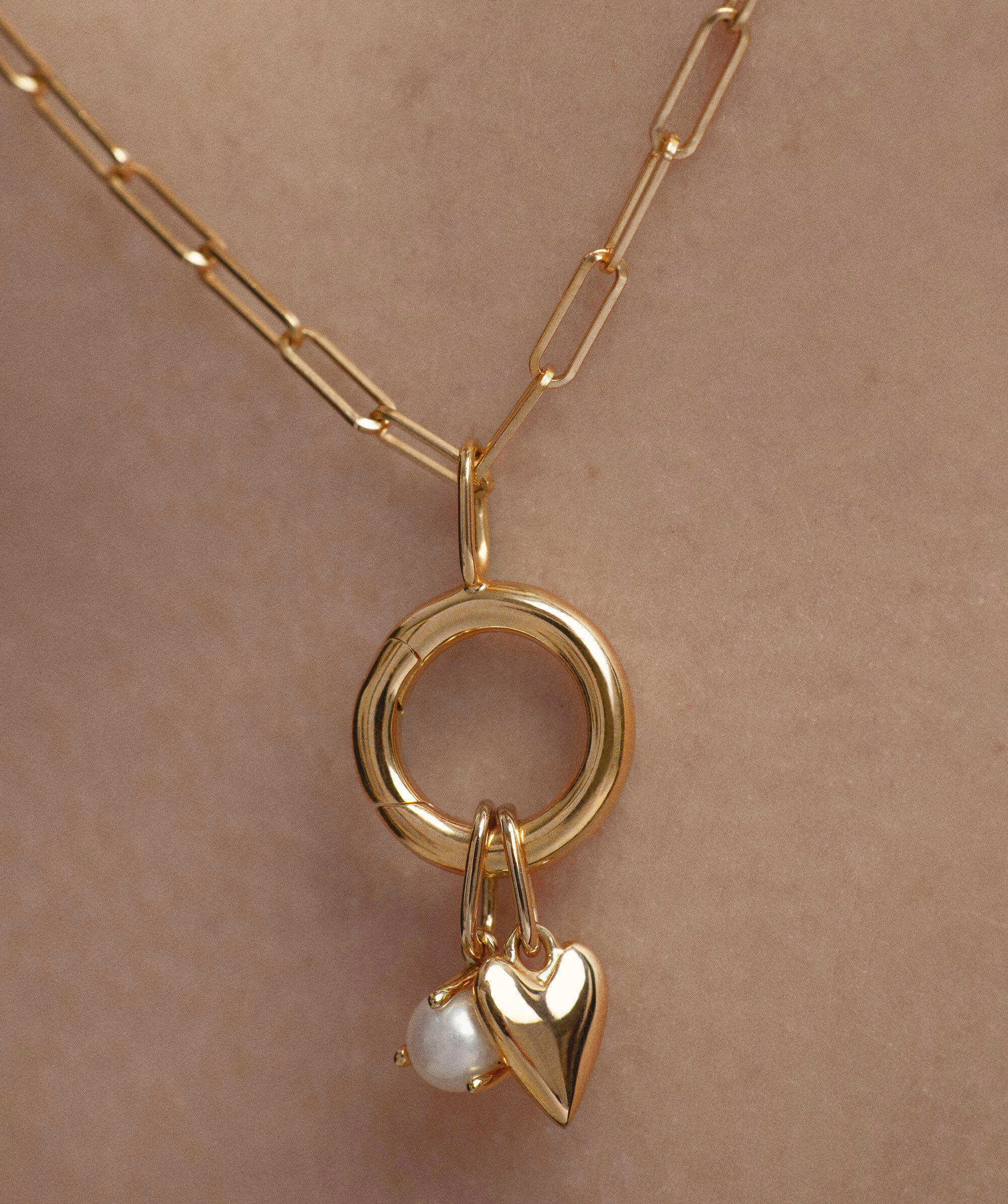 Gold Heart Charm pendant with a pearl, featured on a chain, symbolizing love. Ideal for necklaces or bracelets.