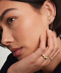 Close-up of a woman's face showcasing PavÃ© Diamond X Oversized Studs in 14k gold with pavÃ© diamonds, highlighting elegance and craftsmanship.