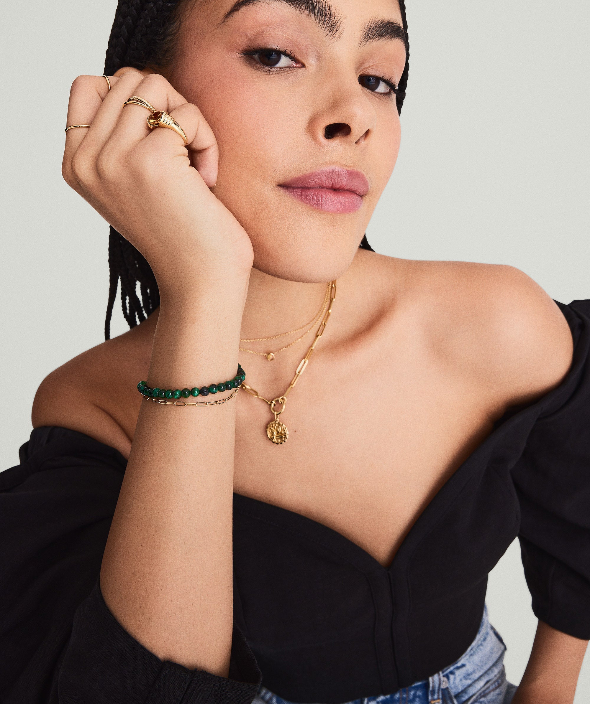Woman showcasing the 4mm Gemstone Beaded Bracelet, handcrafted in sterling silver, with a swivel clasp, while gently touching her face.