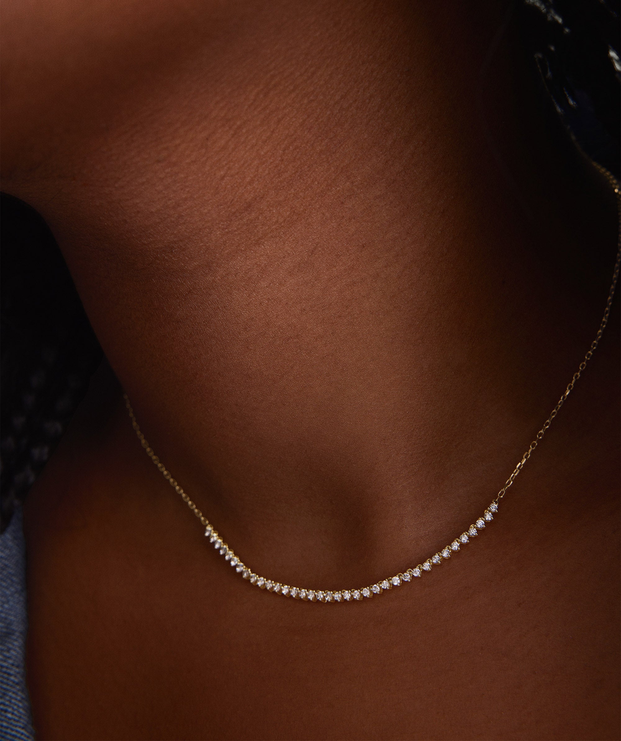 Diamond Half Tennis Necklace, a close-up of a handcrafted 14k gold chain adorned with sparkling, responsibly sourced diamonds, elegantly worn on a woman's neck.