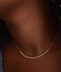 Diamond Half Tennis Necklace, a close-up of a handcrafted 14k gold chain adorned with sparkling, responsibly sourced diamonds, elegantly worn on a woman's neck.