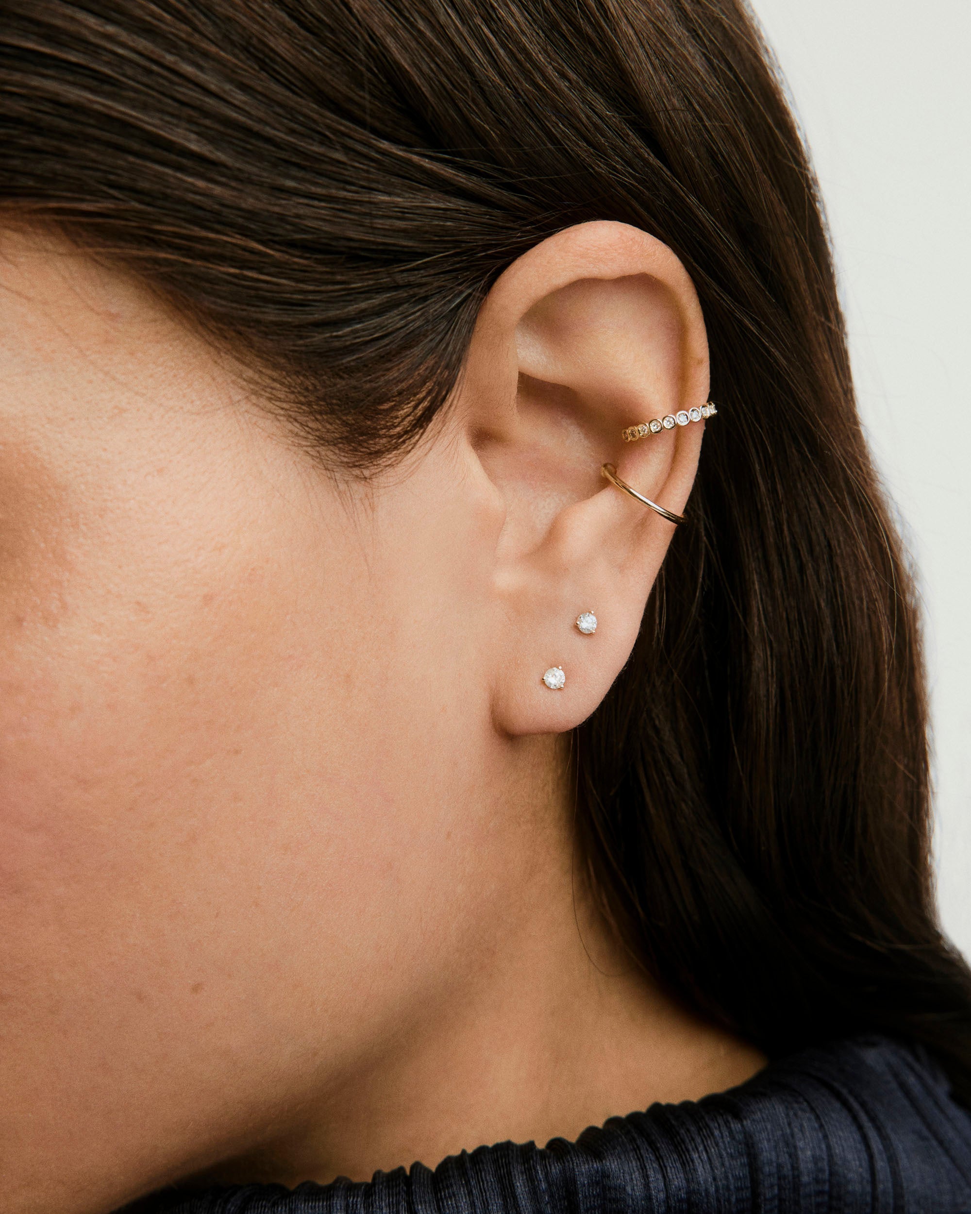 Diamond Mini Studs showcased in a woman's ear, featuring 14k solid gold and 0.06 carat diamonds for a minimal yet bold elegance.
