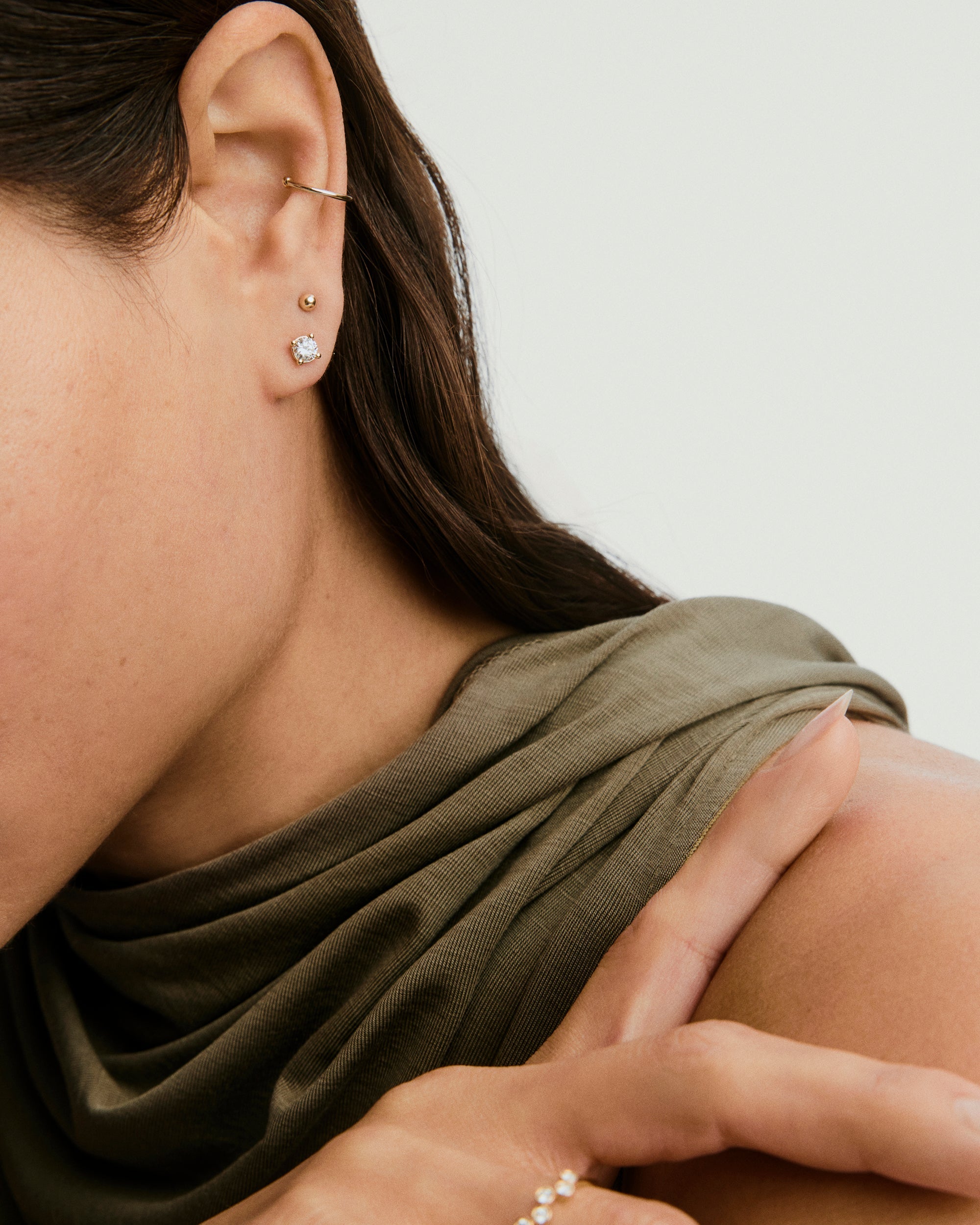 Woman wearing Lab Grown Diamond Round Studs 0.5 TCW in 14k solid gold, showcasing sparkling, ethically produced diamonds close to her ear.