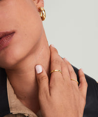 Close-up of a woman's neck and hand showcasing the Diamonds Band, a handcrafted 14k solid gold ring with diamonds, highlighting its elegance and intricate design.
