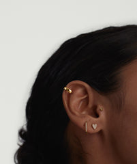 Close-up of a woman's ear adorned with the Piercing Studio - PavÃ© Diamond Heart Flat Back Stud, showcasing a heart-shaped diamond design for a playful statement.