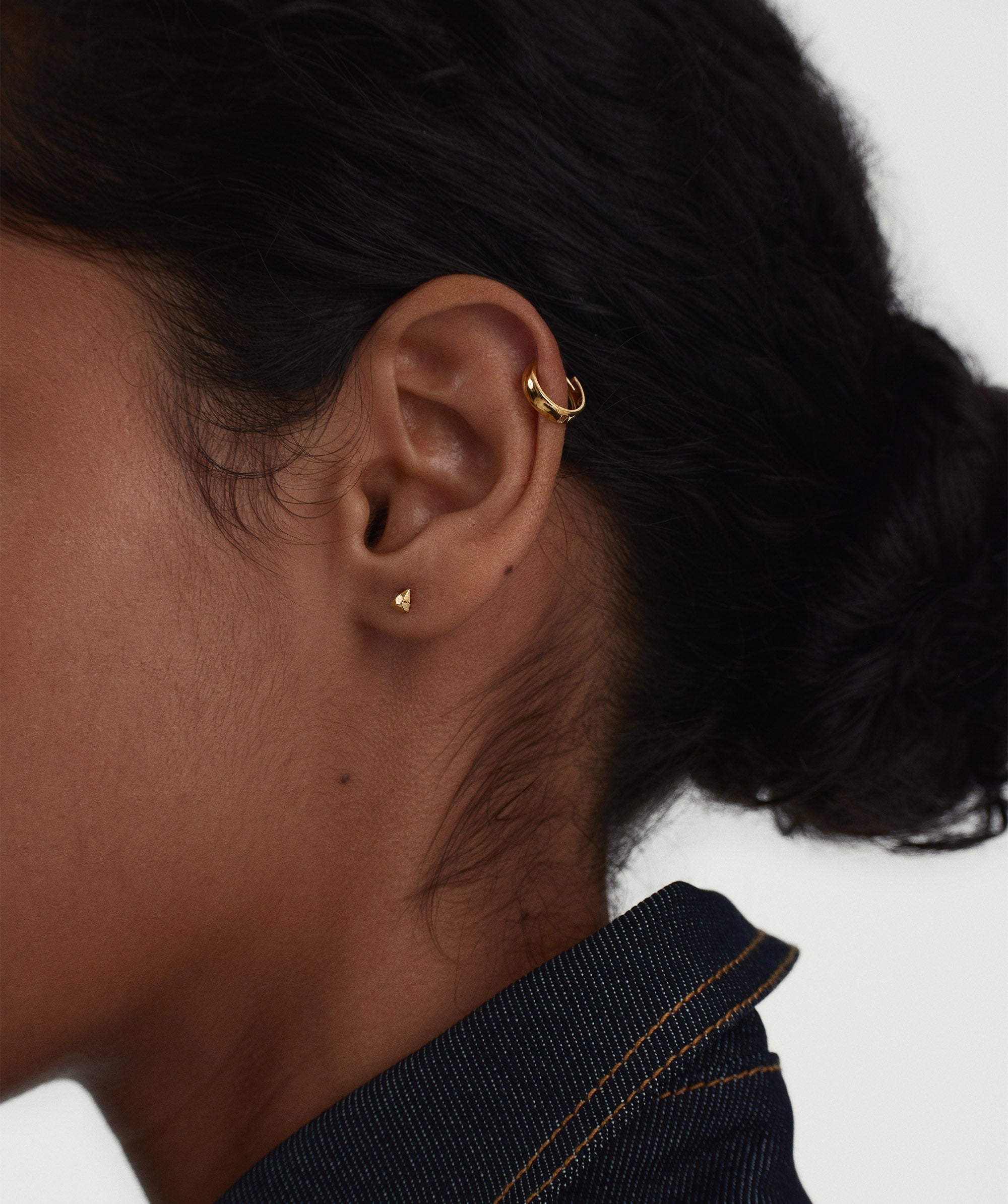 Close-up of an ear wearing the Piercing Studio - Puffy Pyramid Flat Back Stud, showcasing its unique puffy design as a stylish fashion accessory.