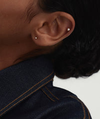 Close-up of a person's ear featuring the Piercing Studio - Micro Diamond Flat Back Stud, showcasing its elegant design and subtle yet impactful presence.