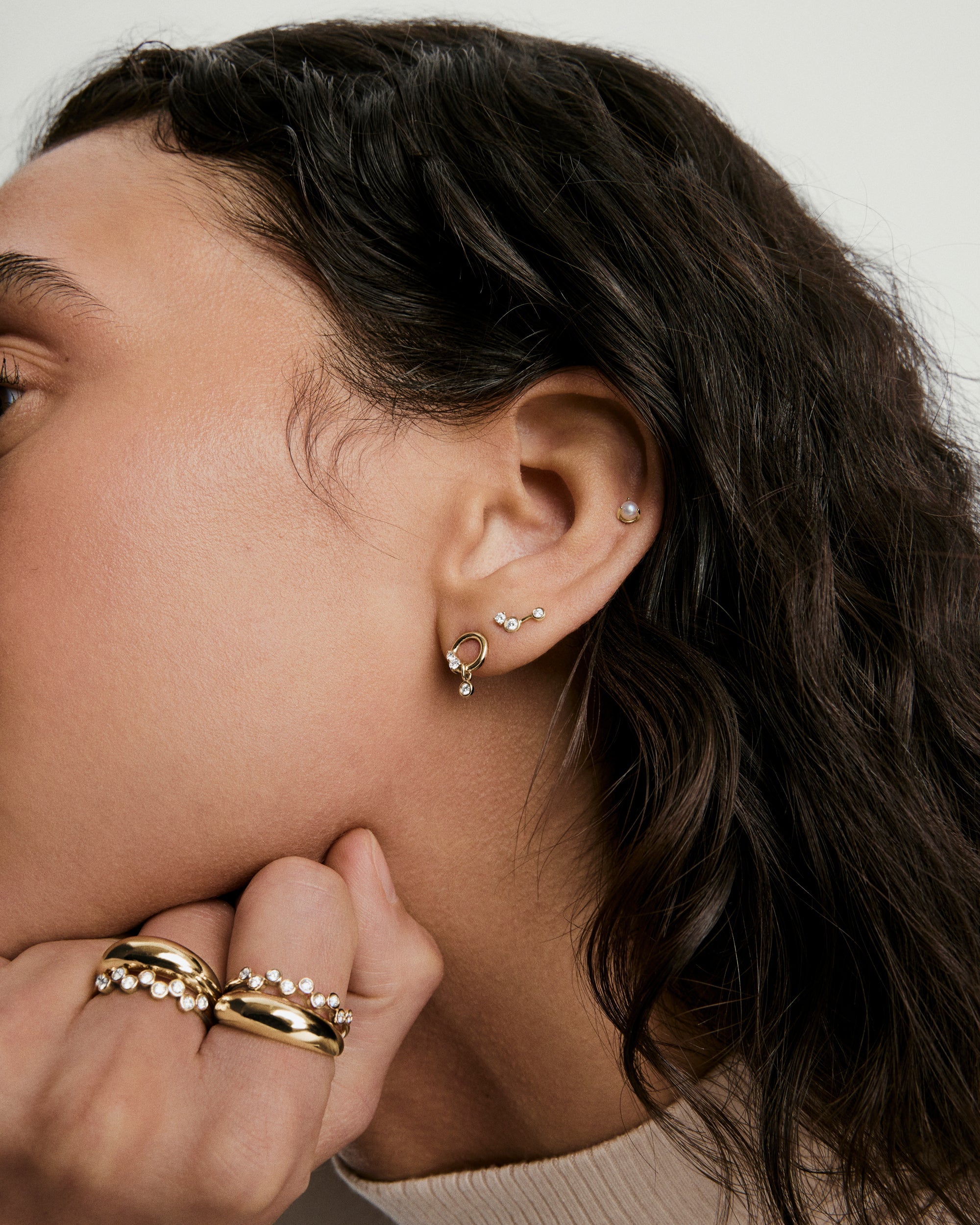 Celeste Lab Grown Diamond Triad Stud earring on woman's ear, featuring three connected diamonds in prong and bezel settings, exuding constellation-inspired elegance.
