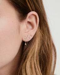 Celeste Lab Grown Diamond Chain Stud on a woman's ear, showcasing clustered diamonds and a dangling drop chain, inspired by night sky constellations.