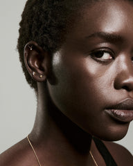 Person's profile showcasing Piercing Studio - Lab Grown Diamond Helix Stud, a sleek bar with fine chain and floating diamond, alongside hoop and stud earrings.