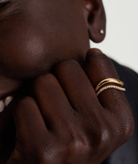 Close-up of a hand showcasing the DÃ´me Figure PavÃ© Diamond Ring, featuring sleek curves and pavÃ© diamonds set in 14k gold.
