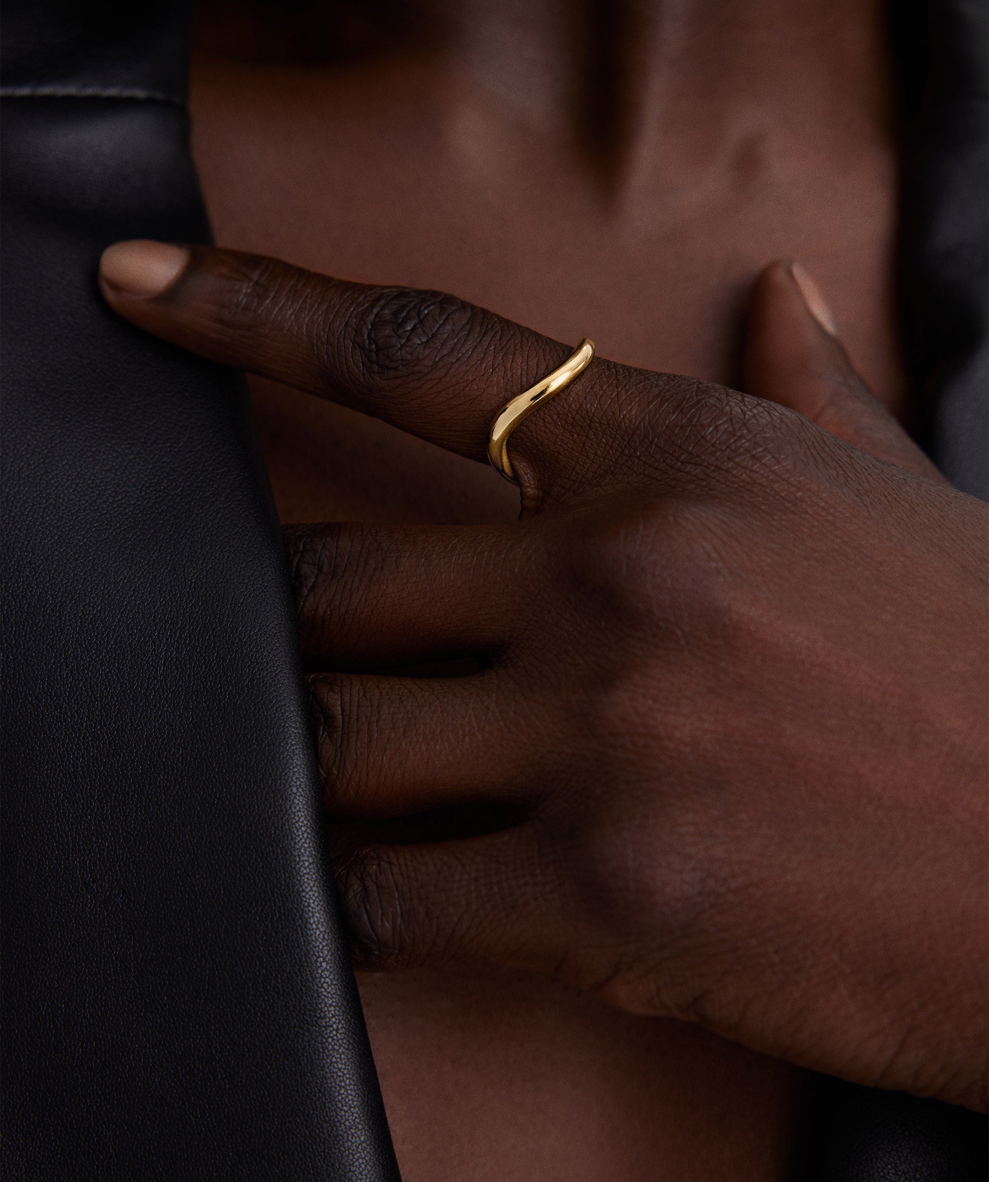 A person wearing the DÃ´me Figure Stacker Ring on their finger, showcasing the handcrafted 14k gold design.