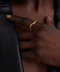 A person wearing the DÃ´me Figure Stacker Ring on their finger, showcasing the handcrafted 14k gold design.