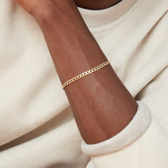 Person wearing Flat Curb Chain Bracelet, showcasing its versatile design as a stylish fashion accessory suitable for any occasion.
