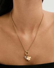 Flat Clover Charm necklace elegantly displayed on a woman's neck, featuring a gold clover adorned with diamonds, exemplifying a playful, lucky fashion statement.