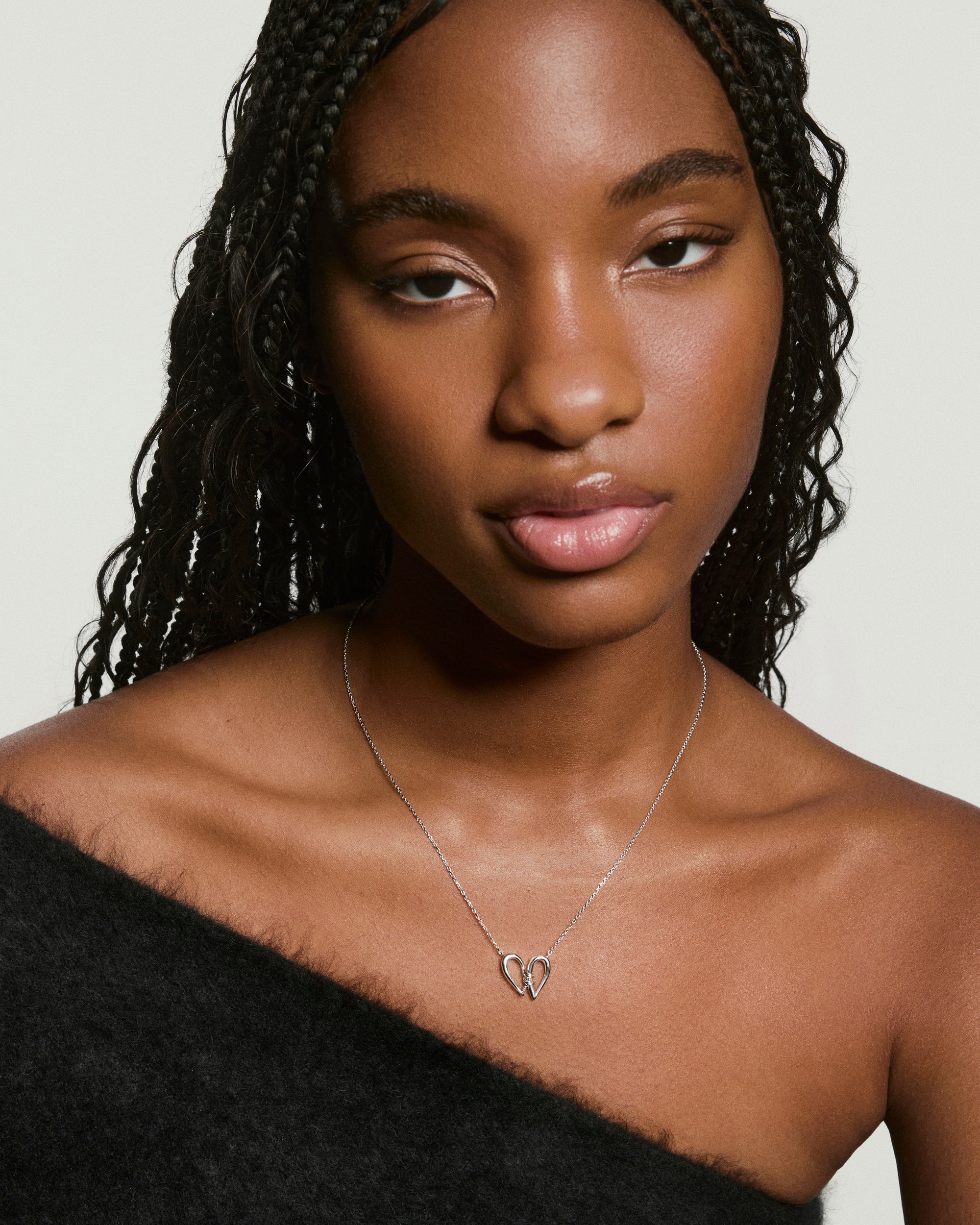 Young woman wearing the Heart to Heart Necklace, featuring a delicate silver chain with a sculptural open-heart pendant, highlighting modern elegance.