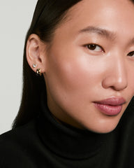 Woman wearing Two of Hearts Studs: a small clear-stone stud and a chunky gold hoop, showcasing their unique half bezel, half prong design.