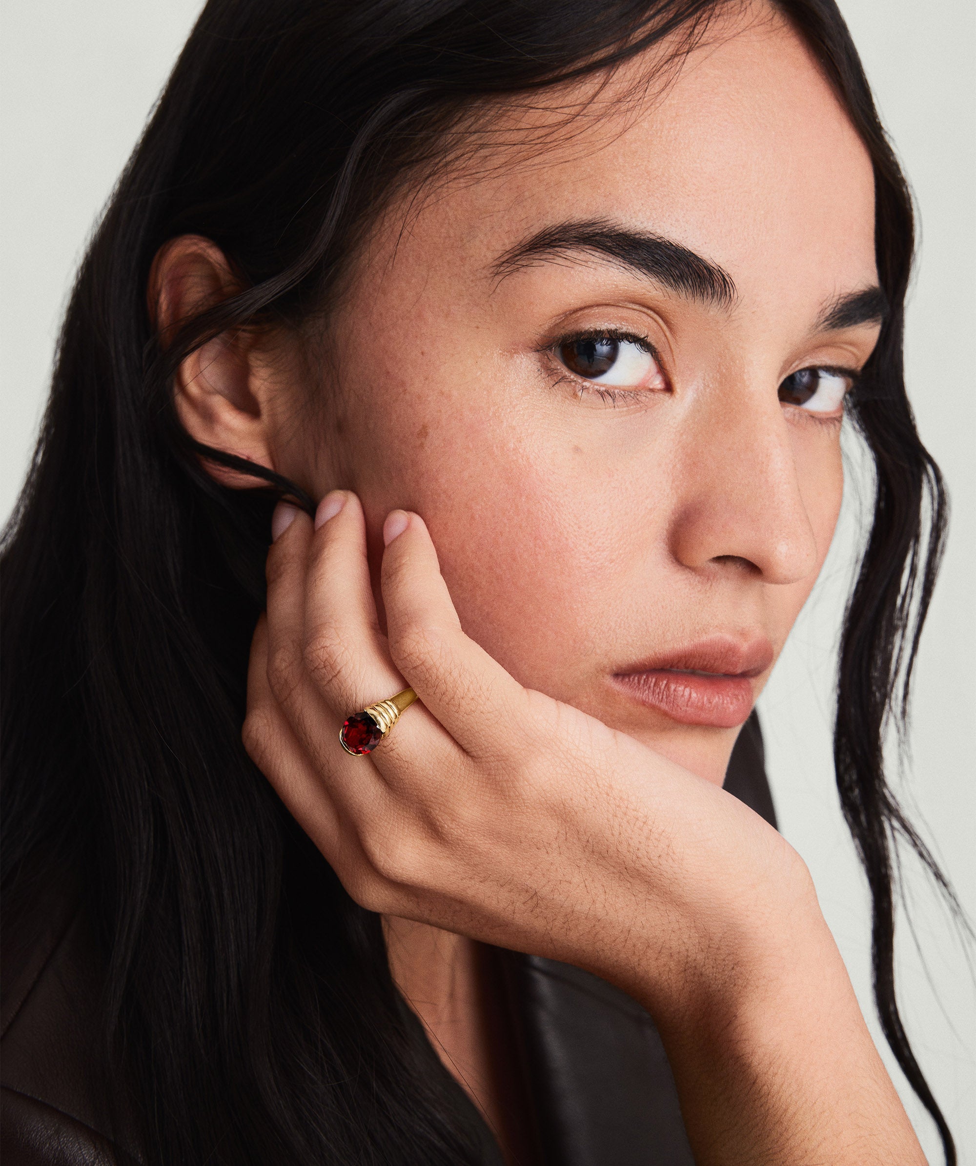 Heirloom Ring showcased on a woman's finger, hand resting on her face, highlighting the ring's intricate design and elegance.