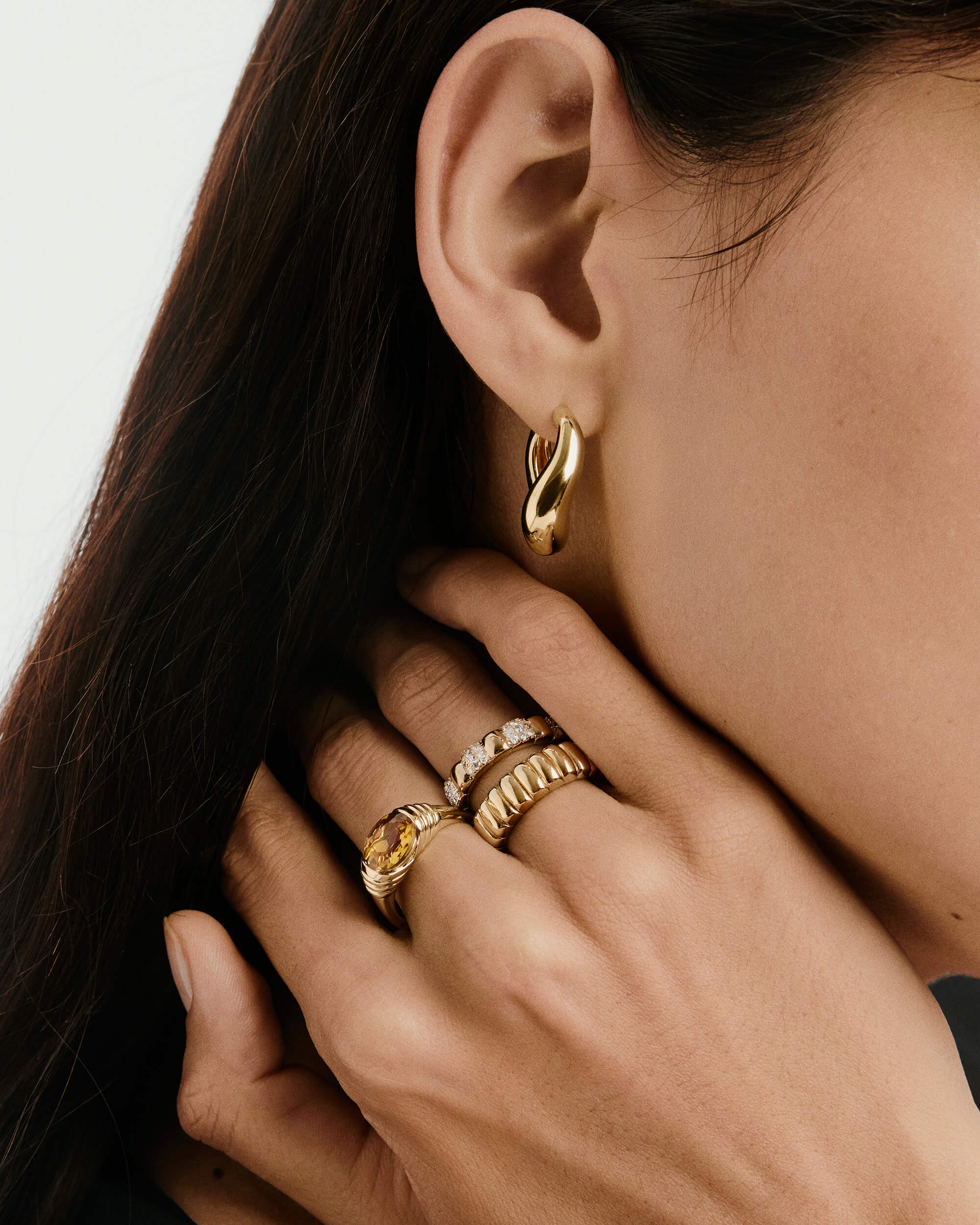 Close-up of a woman's hand showcasing the Heirloom Ring, a gold ring with diamonds, highlighting its elegant design and timeless appeal.