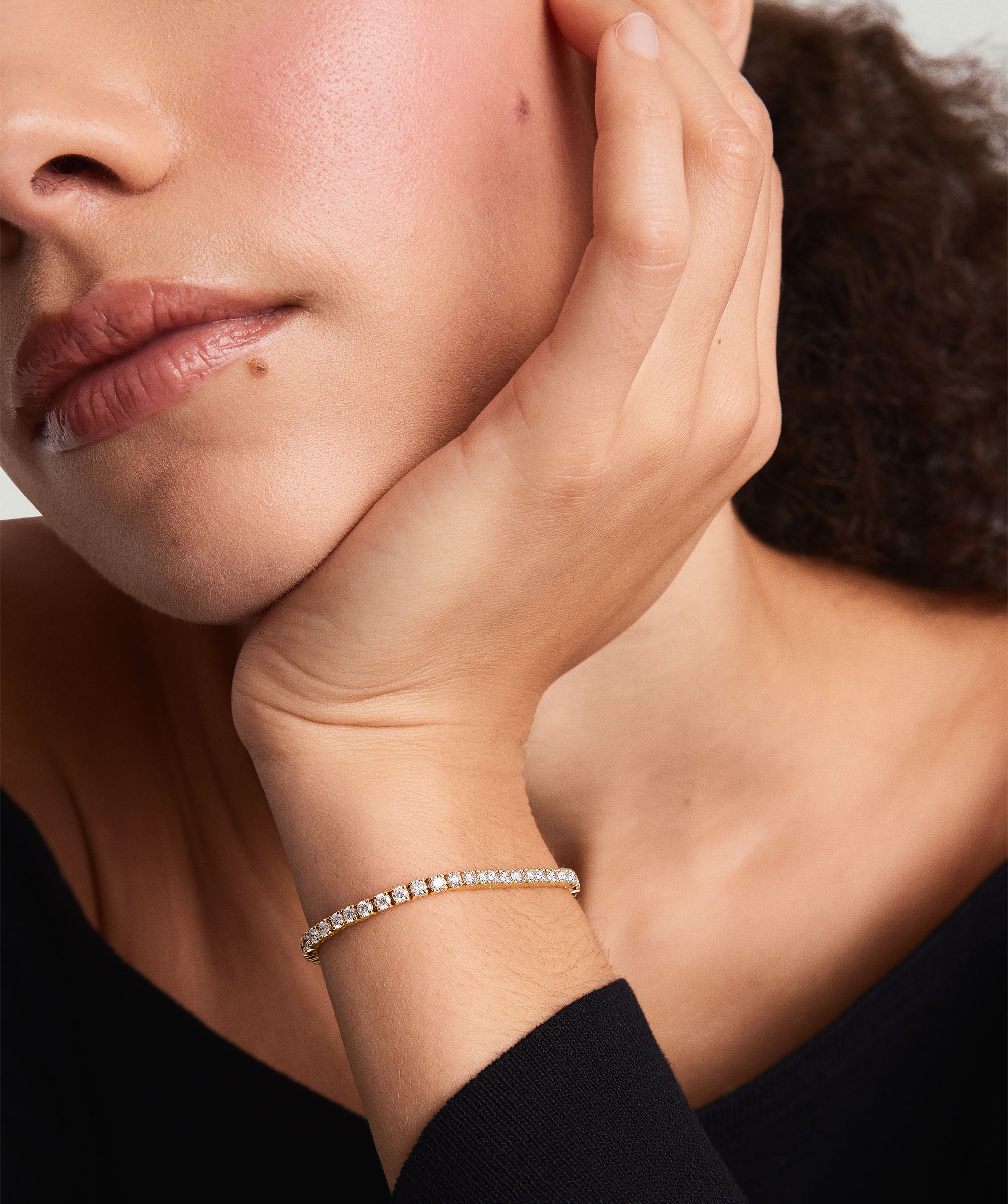 Close-up of a woman wearing a Lab Grown Diamond Tennis Bracelet 2.5mm on her wrist, showcasing its sparkle and secure clasp.